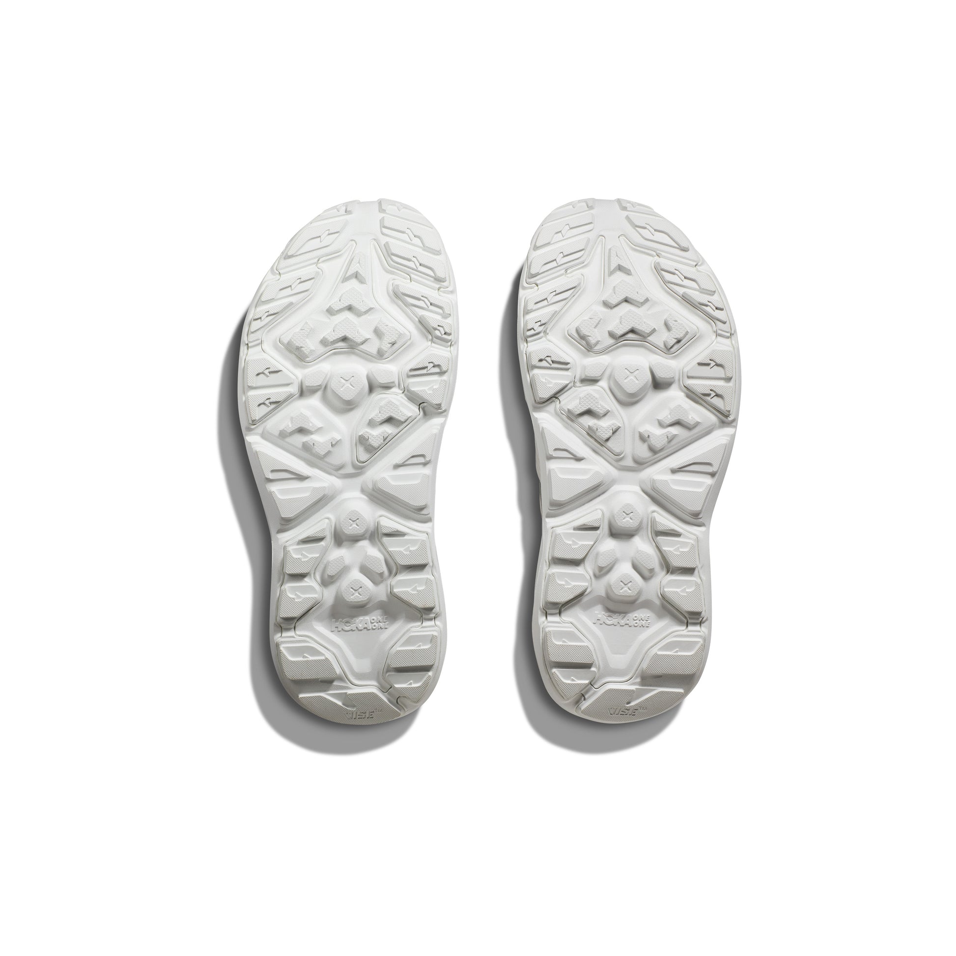 Pair of Hoka U Hopara shoe soles in White/White, facing up to showcase the textured tread pattern and sticky rubber outsole, set against a plain white background.