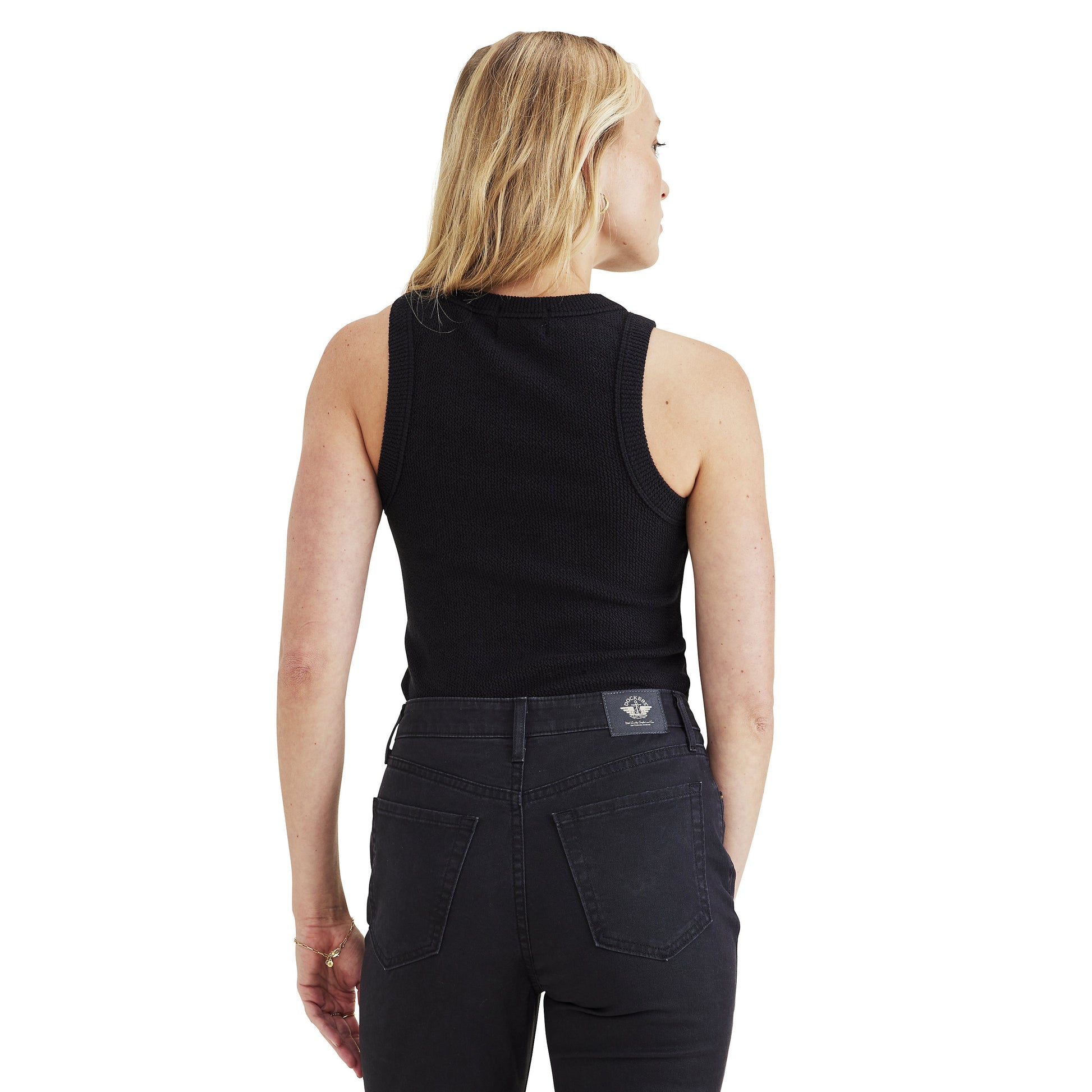 A woman with blonde hair is facing away, wearing a Dockers Women's Rib Tank with Loft Knit in black and dark jeans.