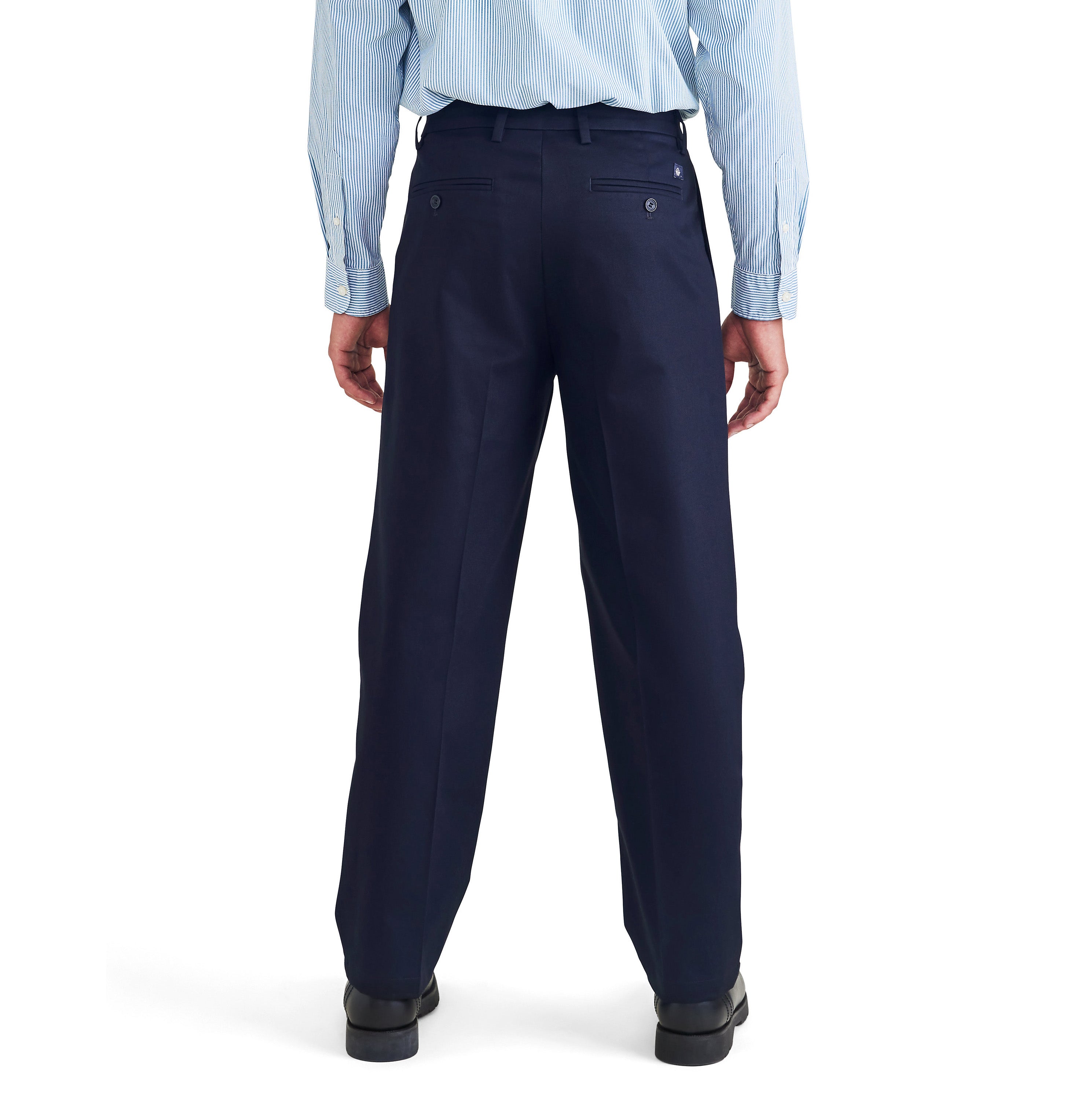 A person faces away, wearing a light blue shirt, Dockers M's Signature Iron Free Pleated Khaki pants, and black shoes.