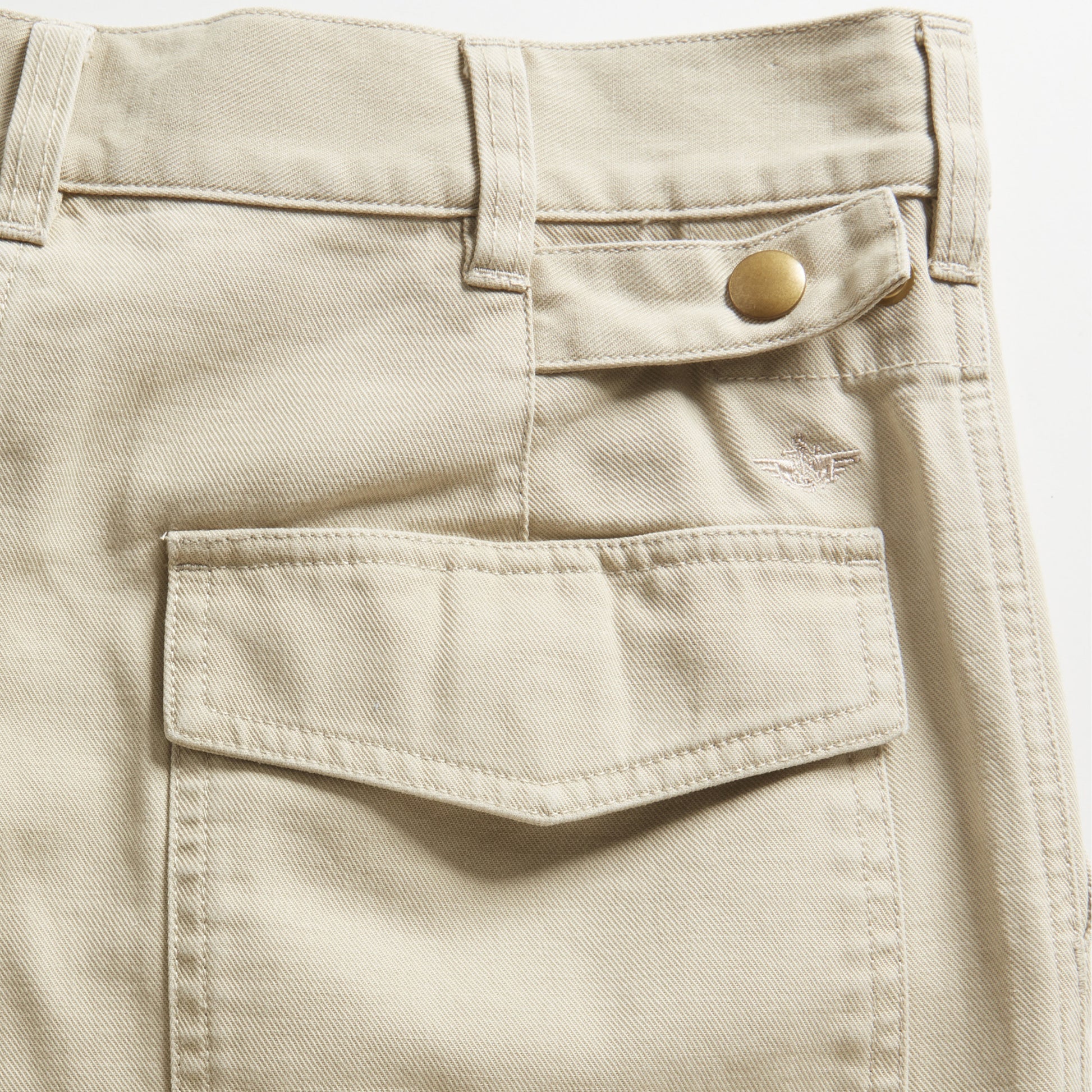 Close-up of the Dockers D-Series Utility Pant, showcasing a large front flap pocket, belt loops, small button tab, and visible stitching from the Transnomadica Collection.