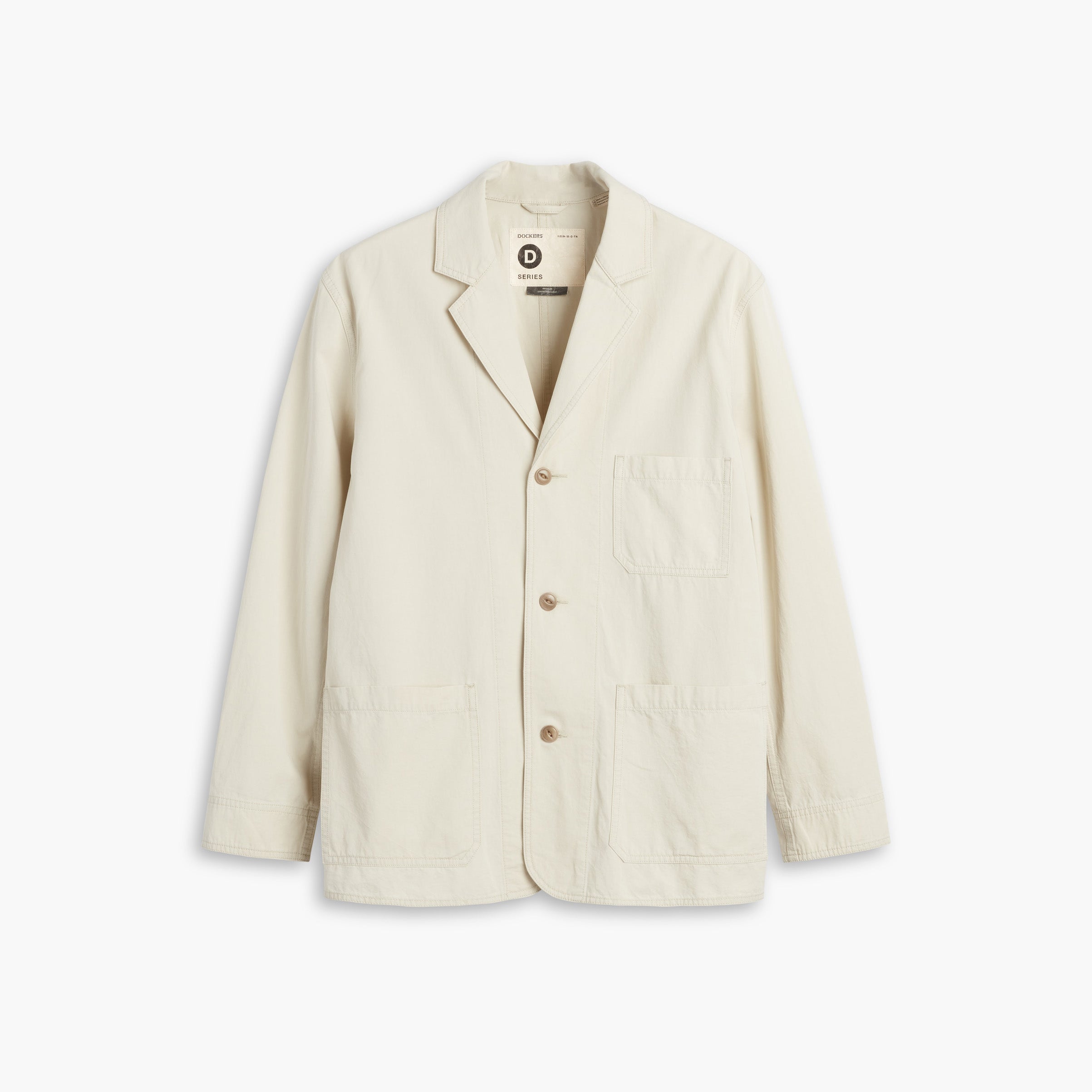 The D-Series Chore Coat by Dockers, from the Transnomadica Collection, is cream-colored and features three buttons, a notched lapel, and three front pockets on a plain white background.
