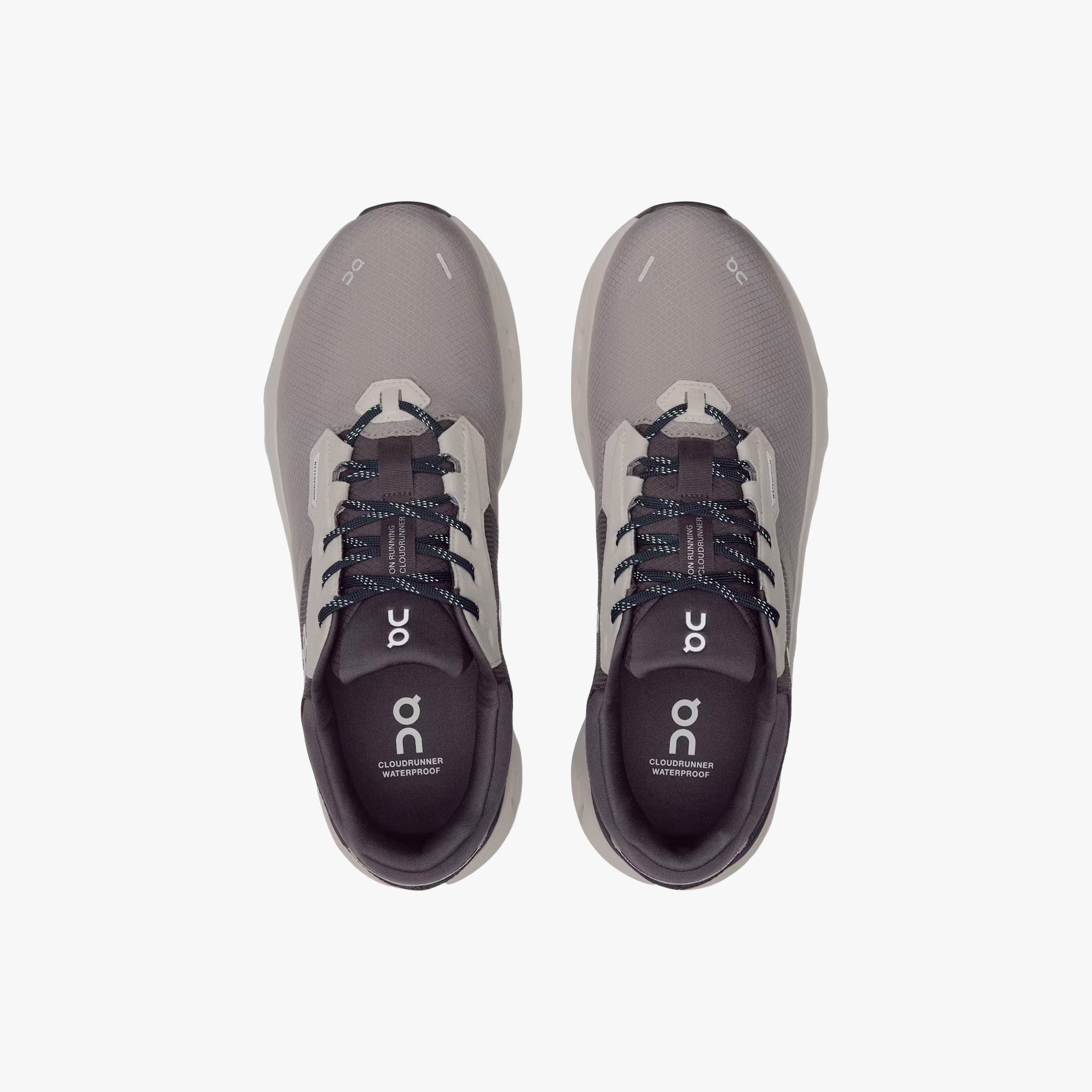 Top-down view of On Running M Cloudrunner 2 Waterproof shoes in Zinc/Midnight, featuring gray and black uppers, white soles, black laces, and the "On" logo on the tongues.