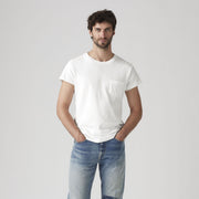 A man stands against a plain background, wearing the Levis LVC 1950's SPRTSWEAR Tee in ultra-soft white jersey with a spade pocket, paired with light blue jeans.