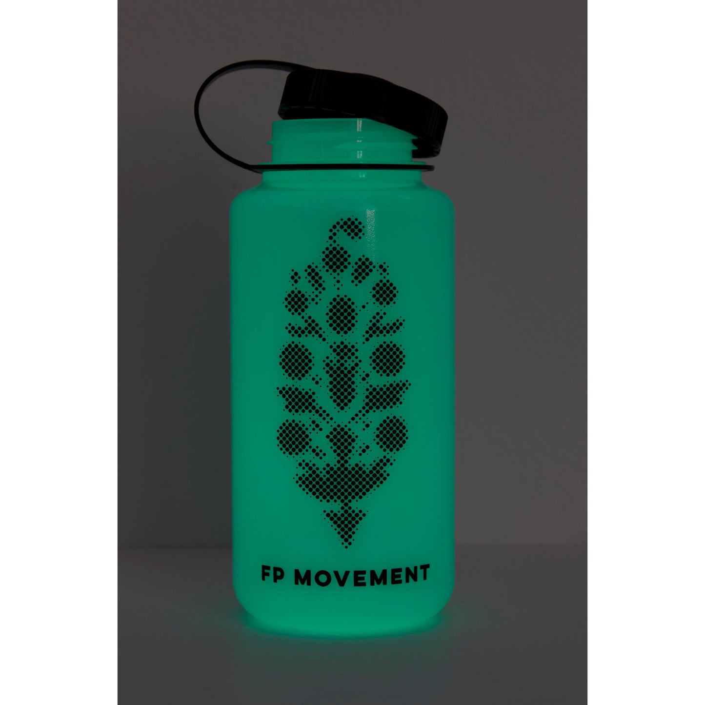 A teal GITD water bottle with a black lid and a dotted pineapple design labeled "Free People Movement" against a gray background.