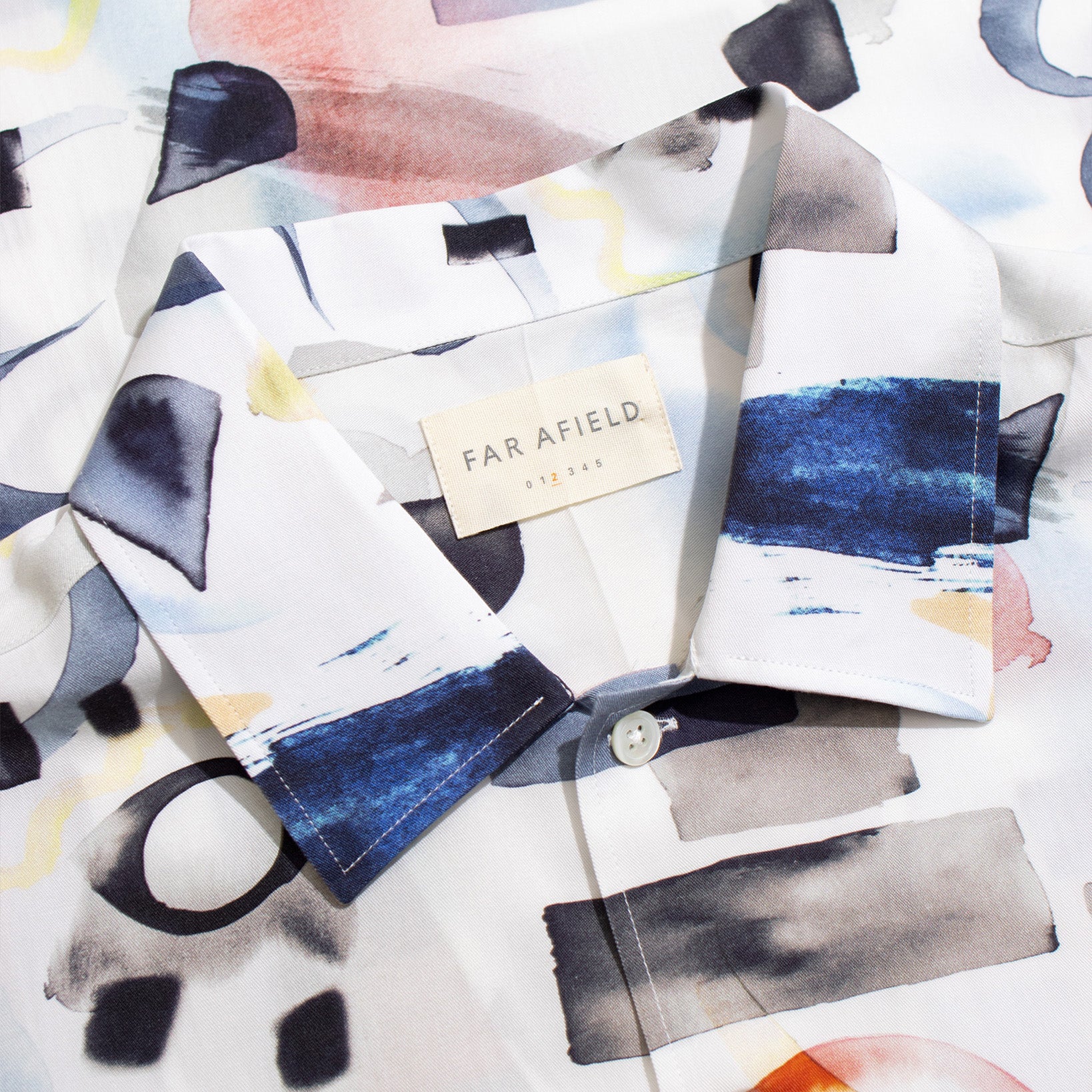 A close-up of the Far Afield Busey SS Shirt, featuring a Doodles print in blue, pink, black, and yellow Tencel™ fabric. Unique print placement brings a modern touch.