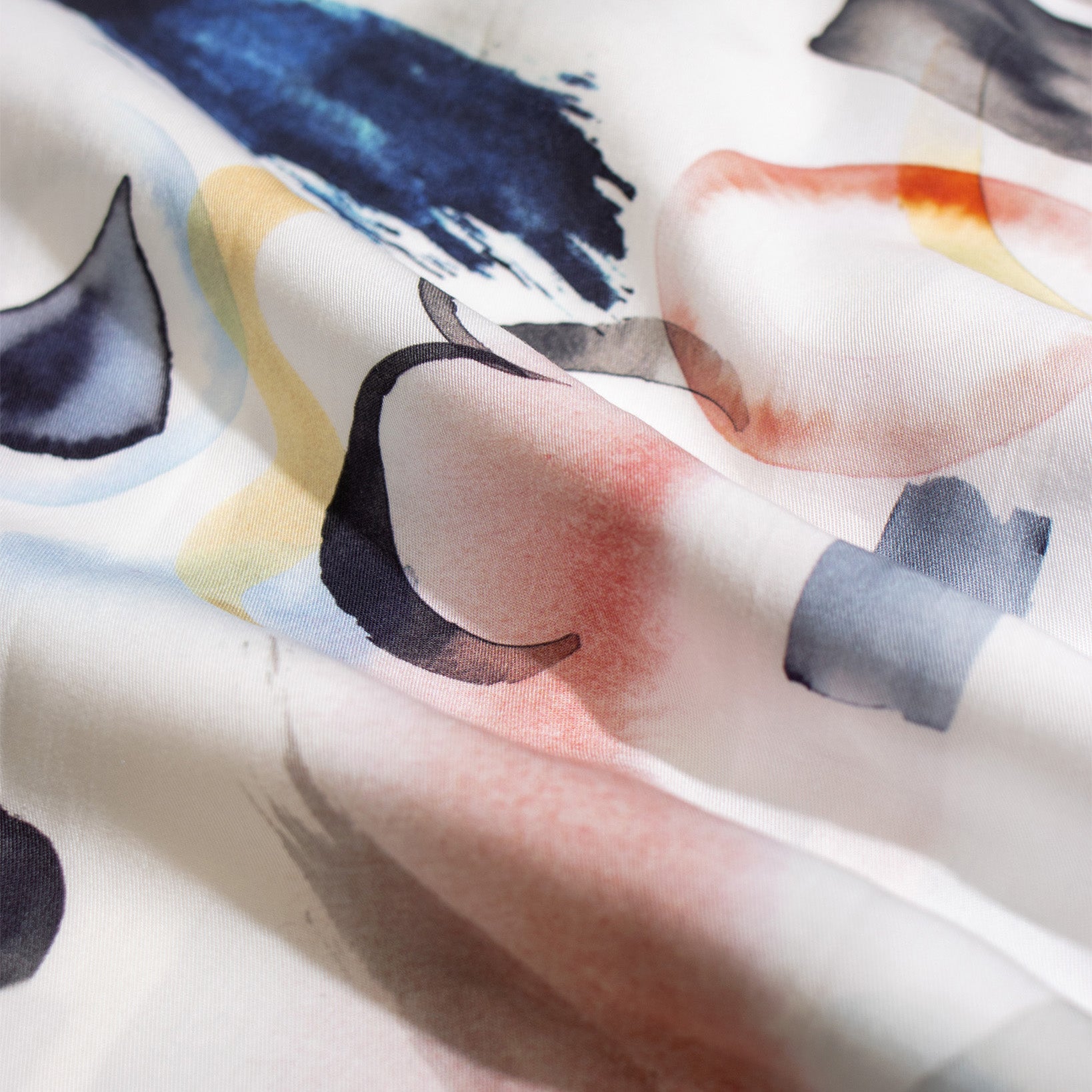 Close-up of the Far Afield Busey SS Shirt in Doodles Print, featuring abstract blue, pink, yellow, and black watercolor shapes on white Tencel™ fabric with unique print placement.
