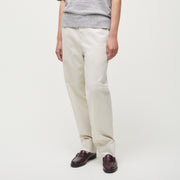 Person with long hair wearing a gray short-sleeve sweater, Aiayu's Coco Pant Tailored Velvet, and brown shoes stands against a plain white background.