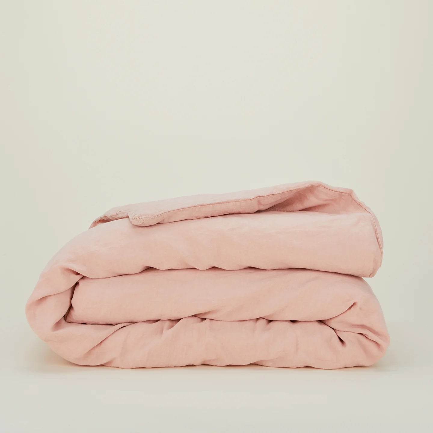 The Hawkins New York Simple Linen Bedding - Queen Duvet Cover in pale pink is neatly folded and displayed against a plain off-white background.