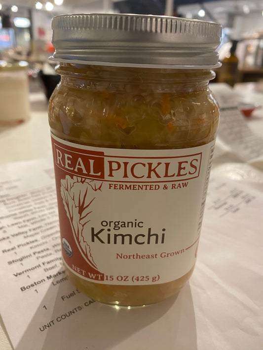 A jar of Westerlind organic kimchi, fermented and raw, on a table with a paper menu underneath.