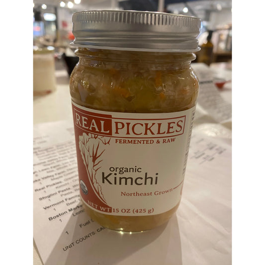 A jar of Westerlind organic kimchi, fermented and raw, on a table with a paper menu underneath.