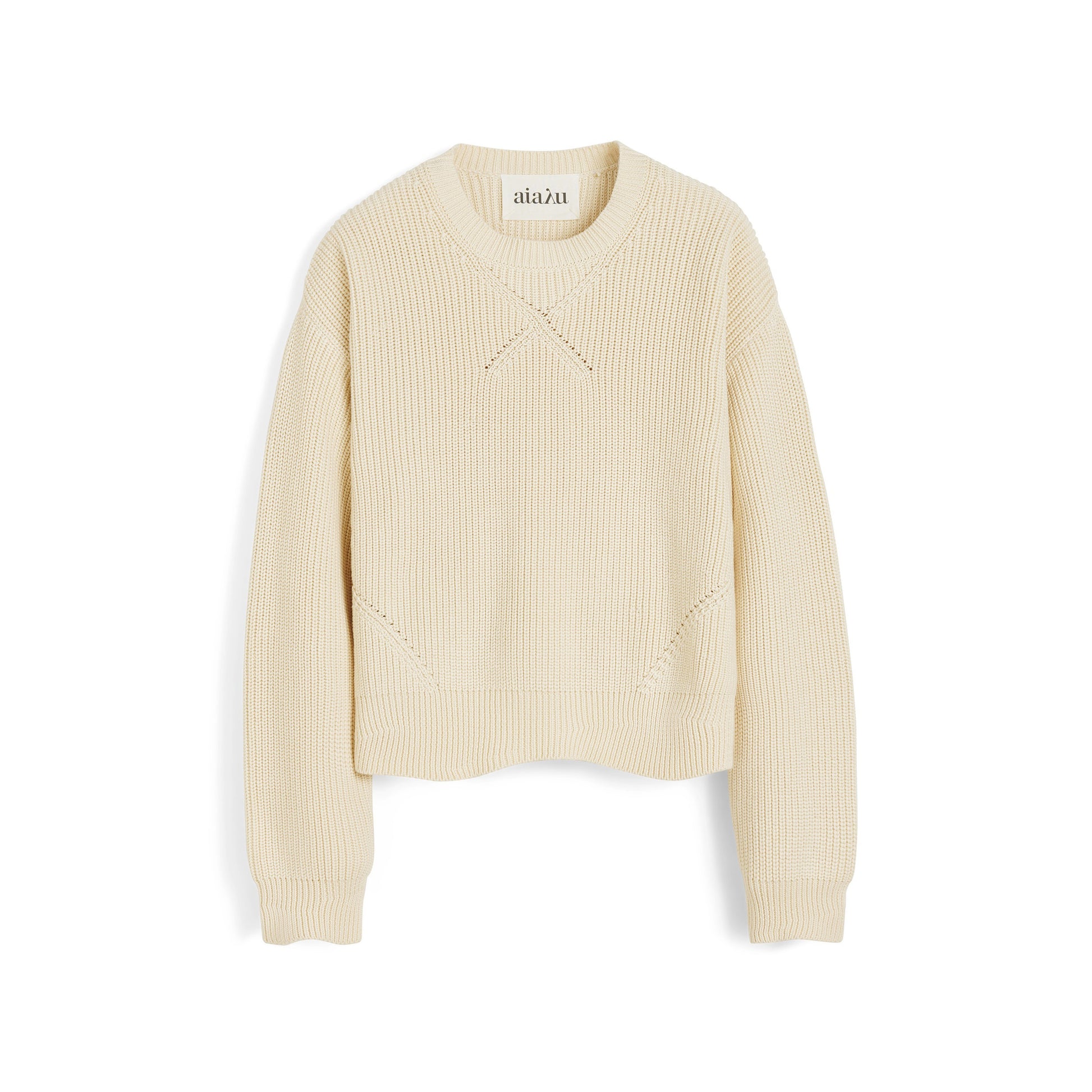 The Kindra Sweater by Aiayu is a cream, long-sleeve ribbed knit made from soft organic cotton, featuring a crew neck with a small V-shaped stitch below the collar.