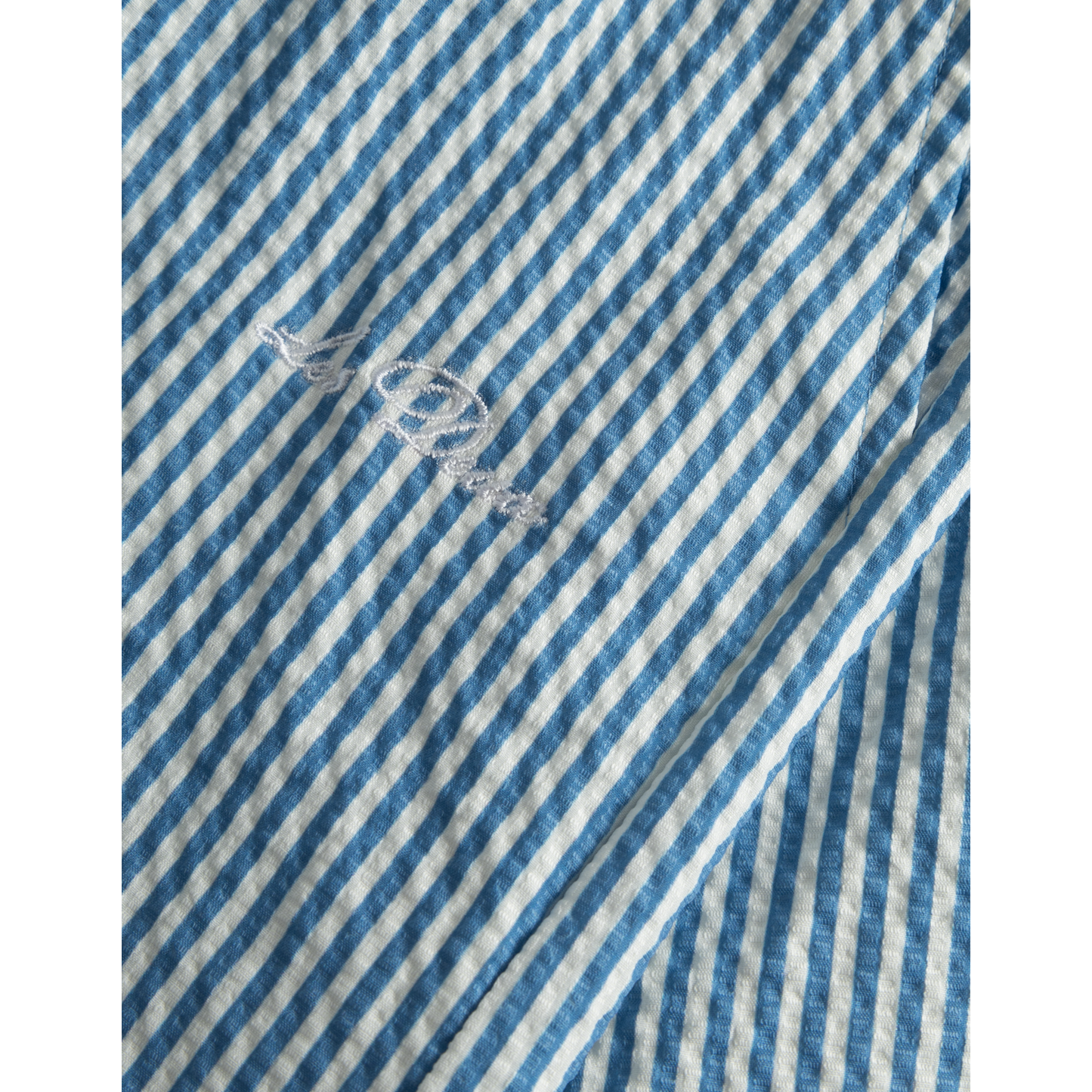 Blue and white Stan Stripe Seersucker Swim Shorts by Les Deux with a small embroidered logo detail.