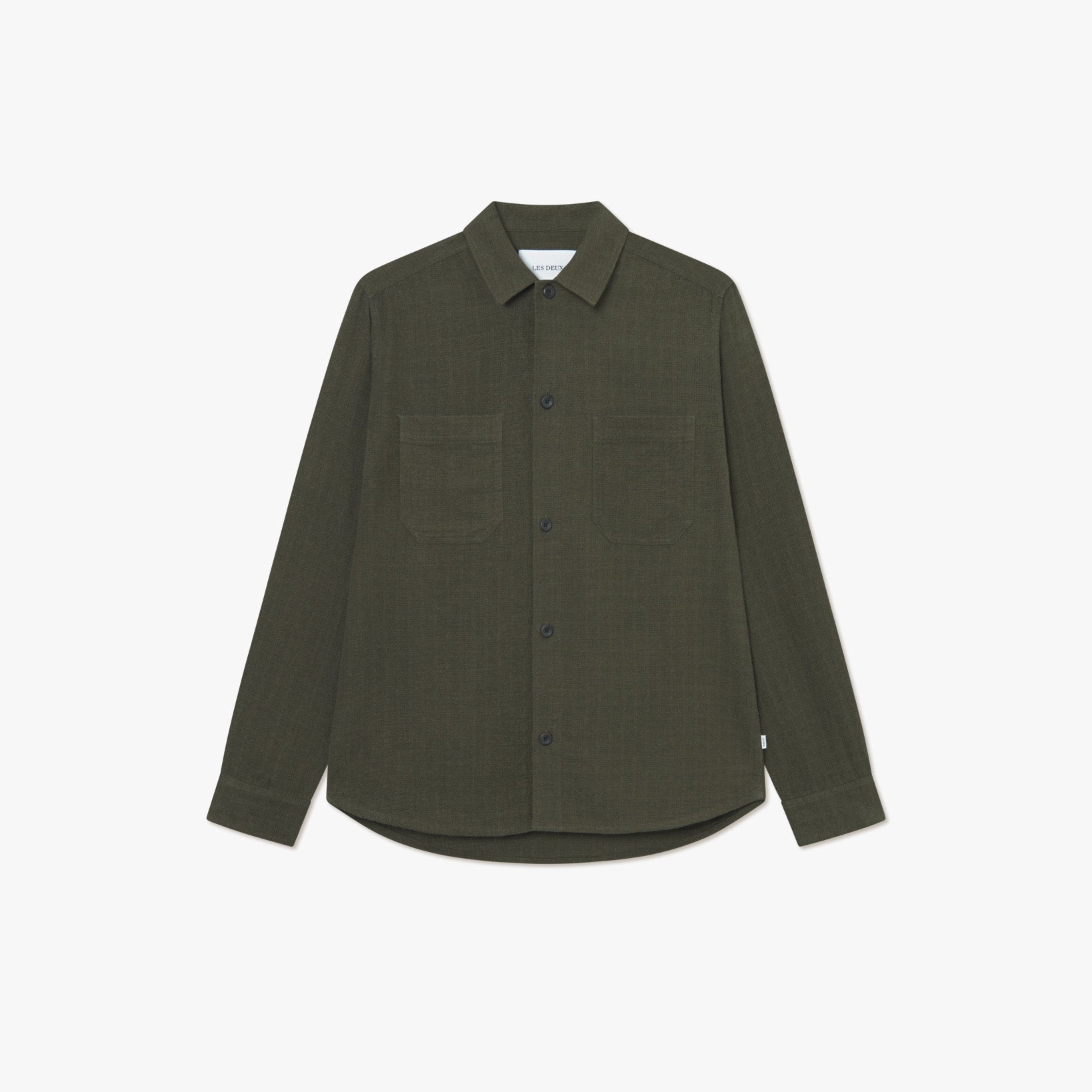 The Les Deux Hamilton Overshirt is a long-sleeve, dark green linen blend button-up with two chest pockets, shown on a plain white background.