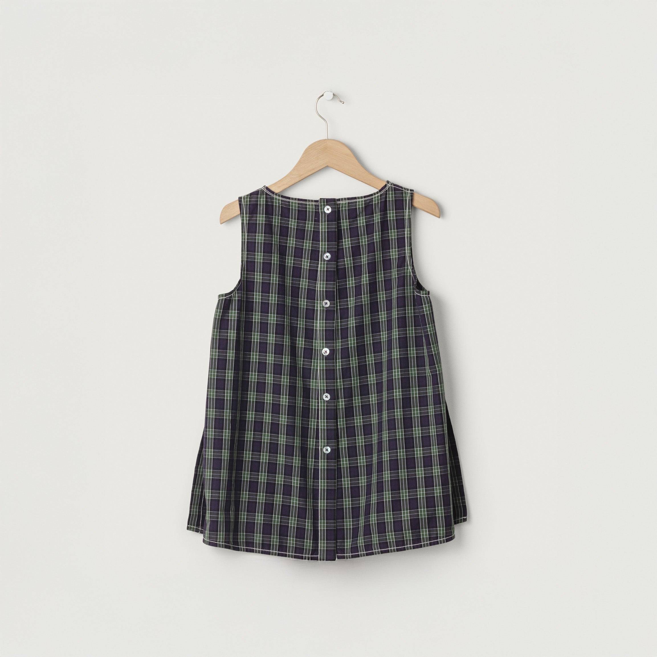 Louise Tank by Jan Machenhauer, a sleeveless button-down tunic in a purple check pattern, displayed on a wooden hanger against a plain white background.