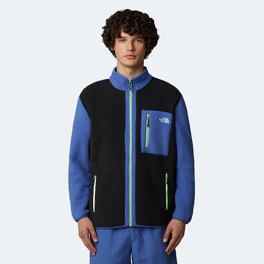 Someone wears The North Face M Yumiori Full Zip fleece jacket in black/blue with green zippers, providing warmth for any adventure. They pair it with matching blue pants, seamlessly blending style and functionality.