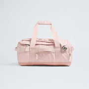 The North Face Base Camp Voyager Duffel - 42L is a light pink bag with two handles, a shoulder strap, and multiple zippered compartments—its lightweight design makes it the ideal travel companion, shown against a plain light background.