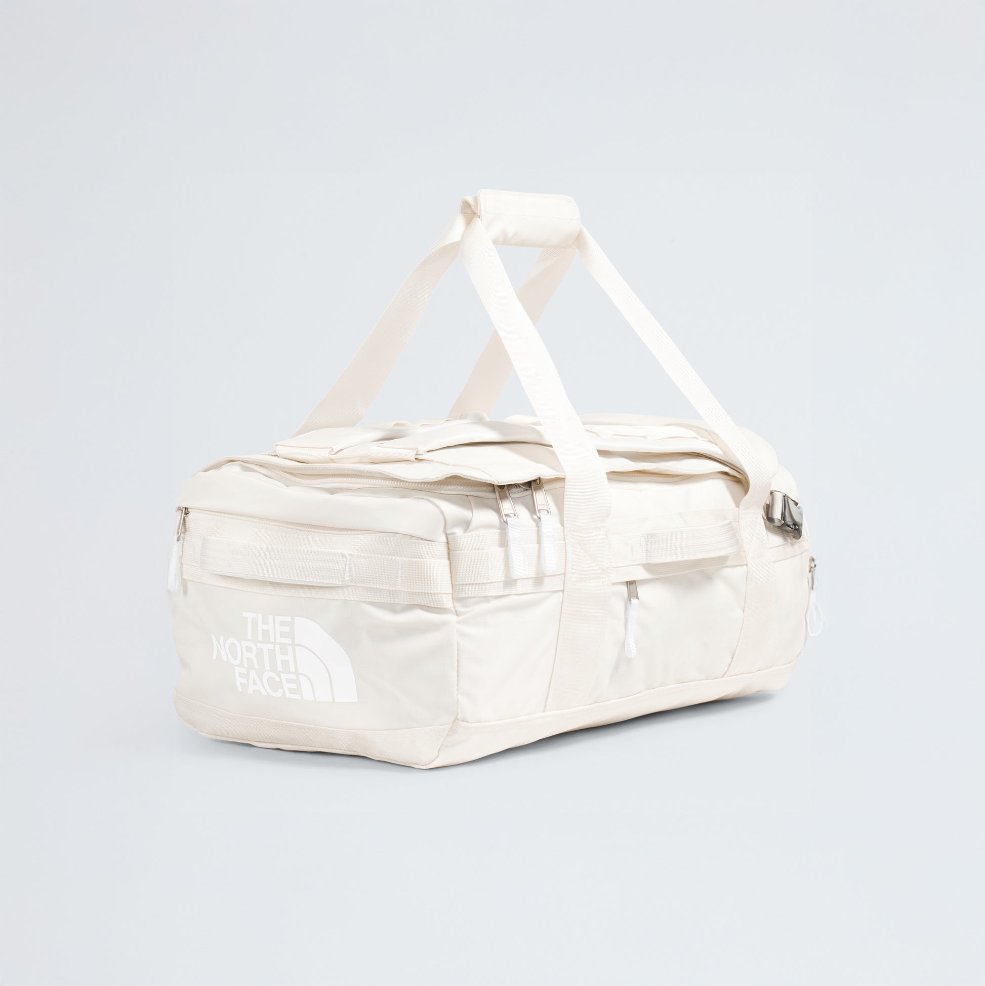 A spacious off-white Base Camp Voyager Duffel - 42L by The North Face with handles and zip pockets, lightweight for travel, shown on a plain light background—an ideal companion for your journeys.