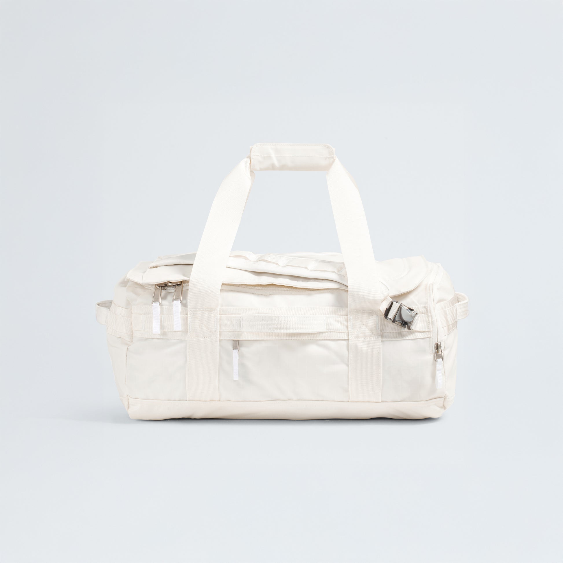 The North Face Base Camp Voyager Duffel - 42L is a white duffel bag with two short handles, a zippered main area, and extra zip pockets—a lightweight travel companion shown on a plain light background.