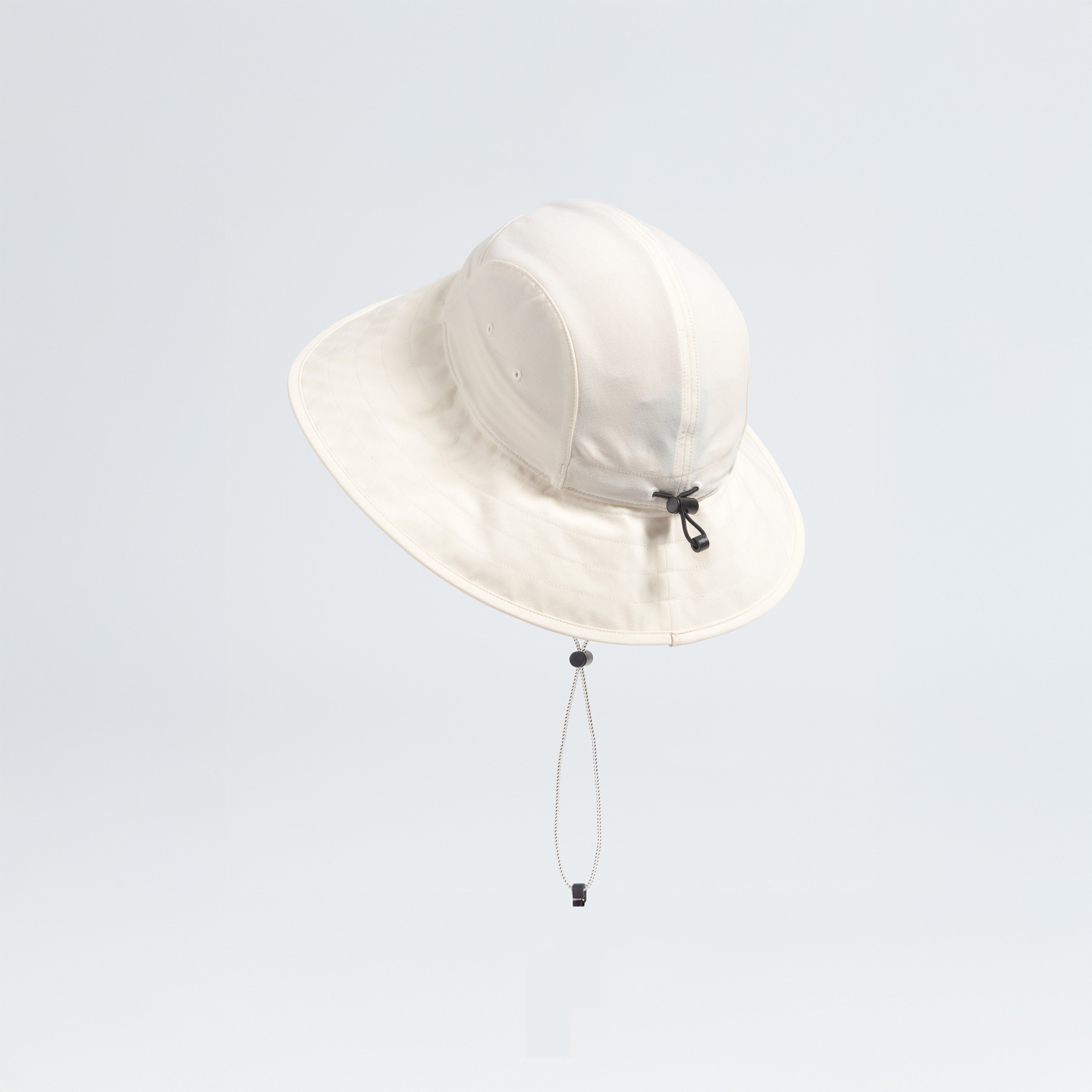 The North Face W Class V Brimmer, a cream-colored wide-brimmed hat with a chin strap, provides essential sun protection against a plain light background.