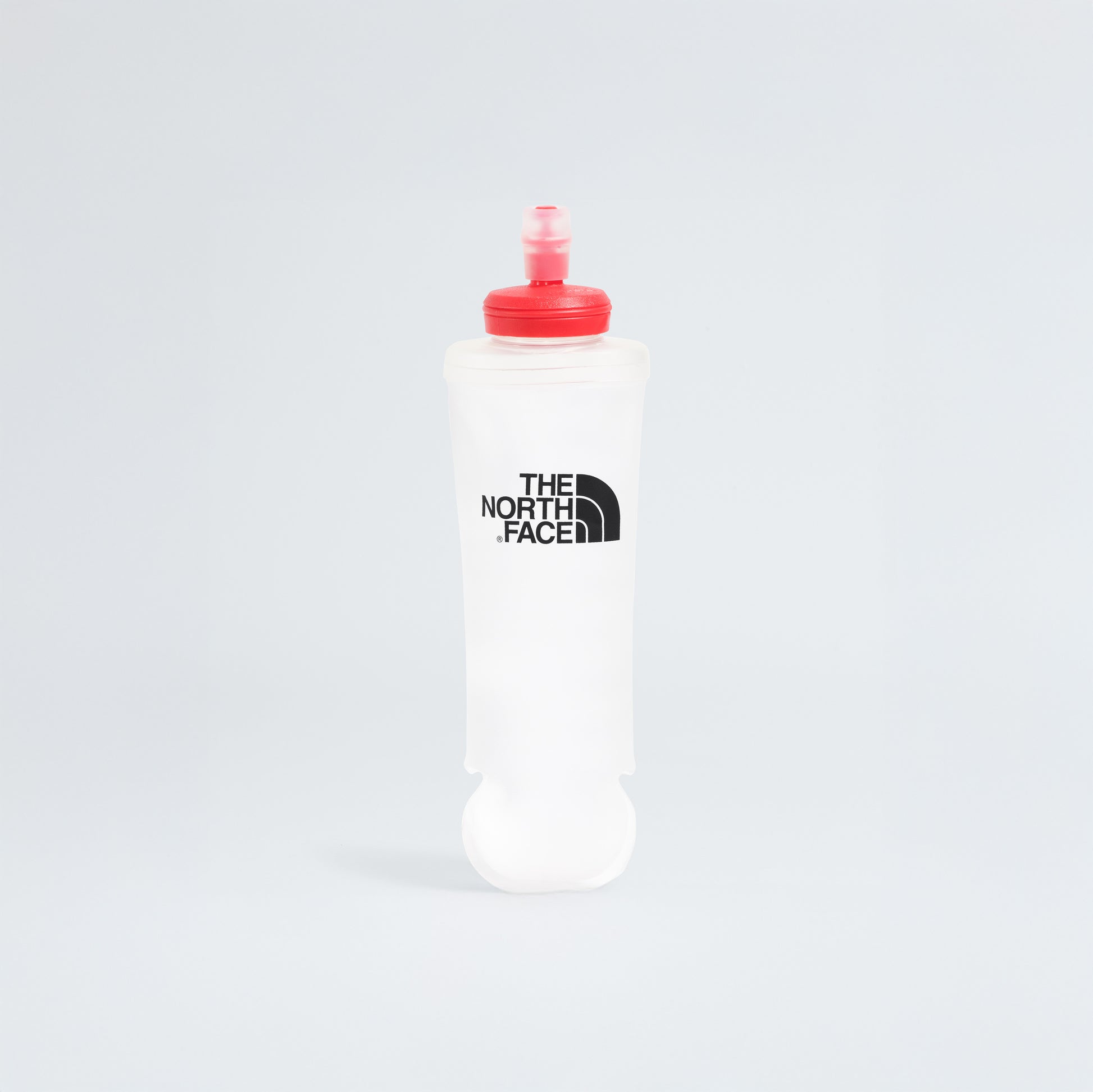Stay hydrated and focused on race day with a flexible water bottle featuring a red cap and The North Face logo, designed to slip perfectly into your U Summit Run Vest 5 against its plain white background.