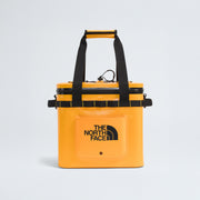 A yellow The North Face Base Camp Cooler 15 Qt with black handles, a front pocket, and the brand logo on the front, displayed on a plain white background.