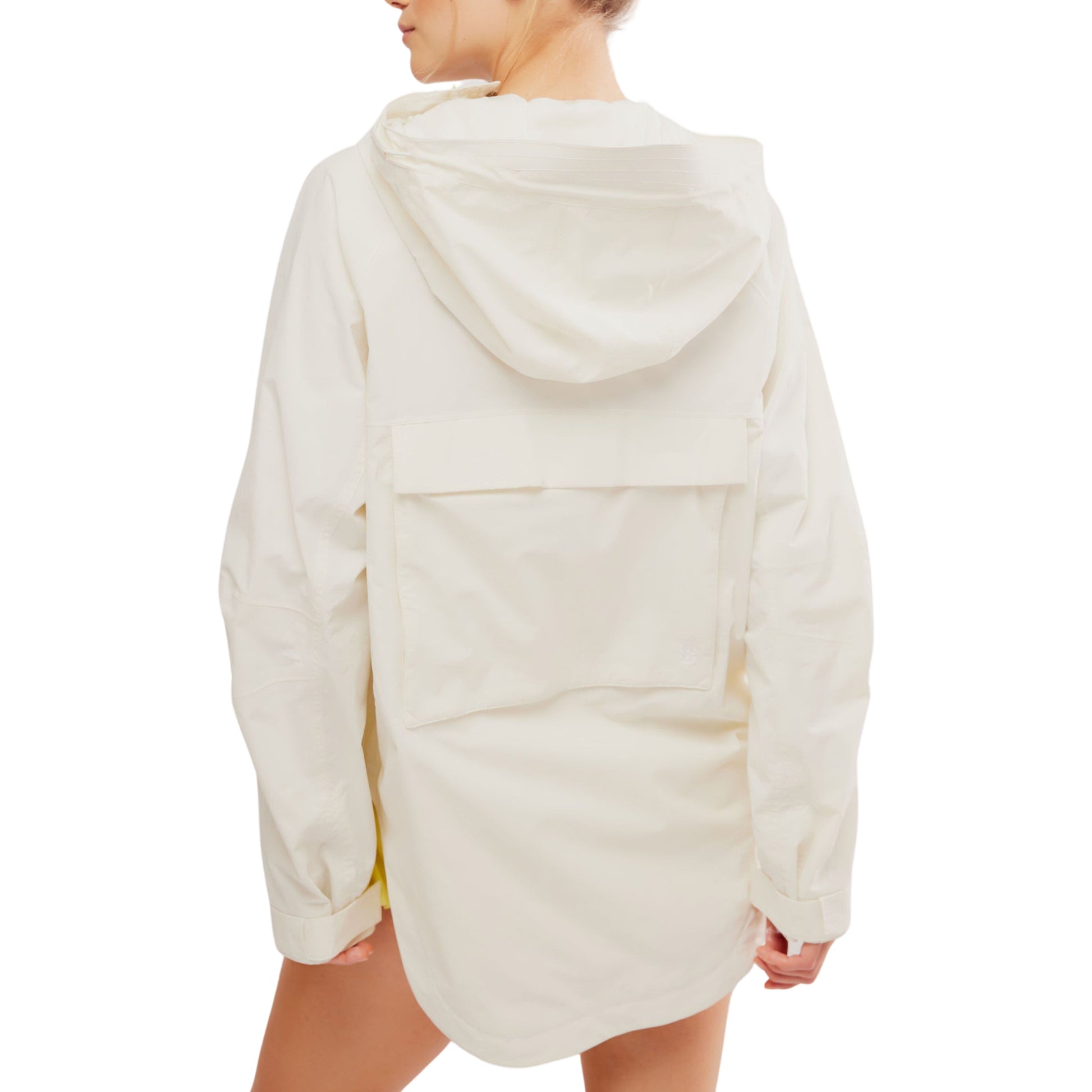 Rear view of a woman wearing a Singin in the Rain Jacket by Free People Movement, featuring a large pocket on the back.
