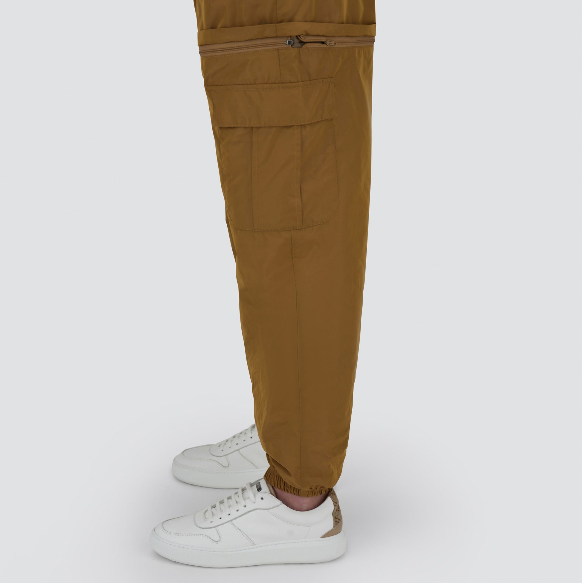 A person wearing Herno's Taffeta Cargo Zip pants and white sneakers, shown from the side against a plain background.