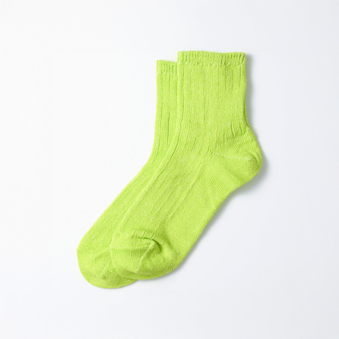 A pair of RoToTo Everyday Pile Ankle Socks in Lime rests on a white surface.