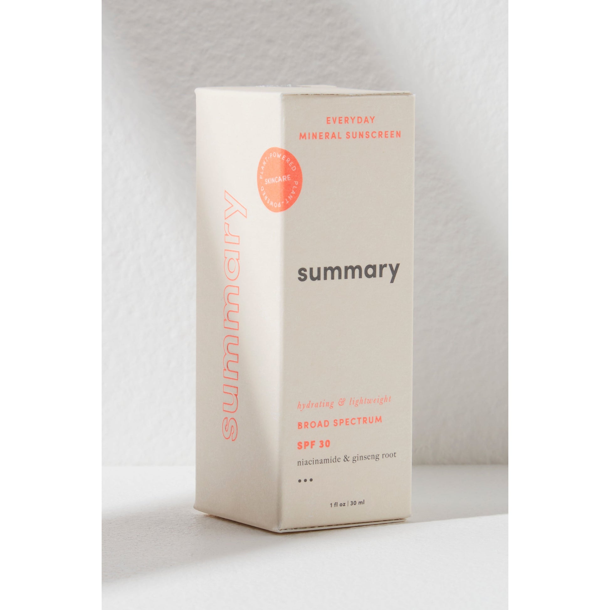 A beige box of "Free People Movement's Summary SPF 30 mineral-based sunscreen" standing upright against a white textured background.
