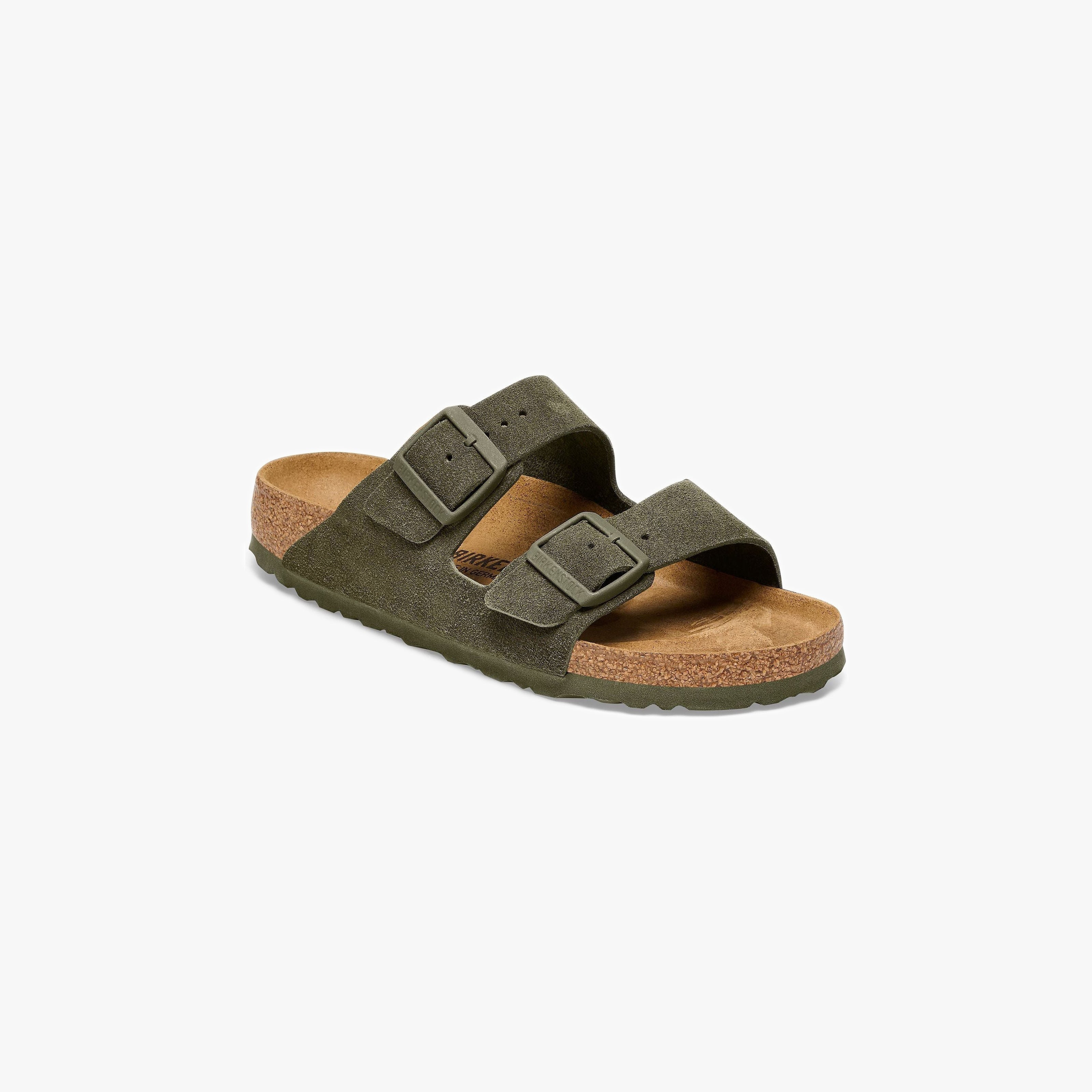Birkenstock’s Arizona Suede sandal in Thyme features two adjustable buckle straps and a cork footbed, shown here in olive green suede on a white background.
