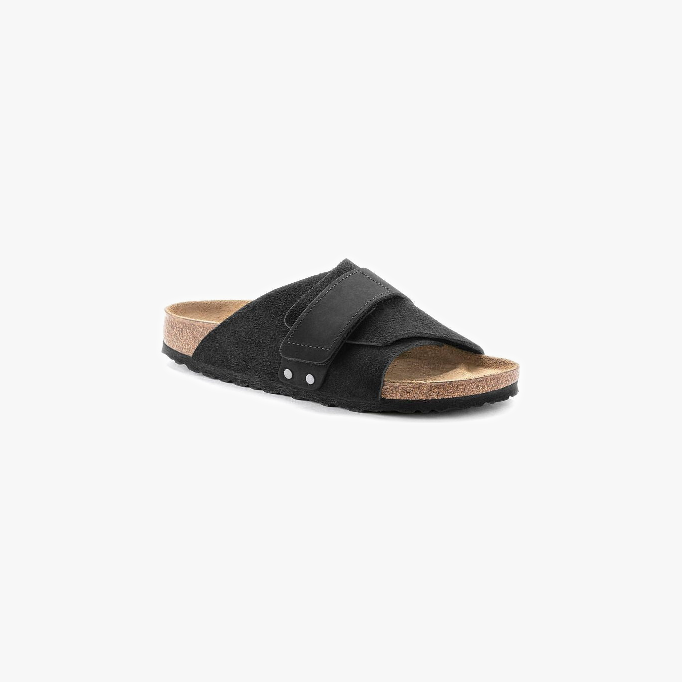 The Birkenstock Kyoto Suede in Black is a slide sandal featuring a cork-latex footbed, suede upper, and a wide adjustable strap with hook and loop closure across the front.