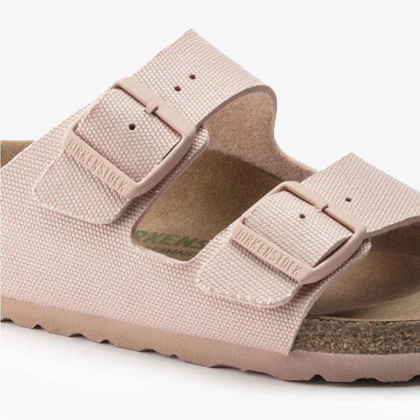 Close-up of the Birkenstock Arizona Vegan sandal in Canvas Soft Pink (W), featuring two adjustable straps, metal buckles, and a cork footbed. Refer to the size chart for accurate Birkenstock sizing.