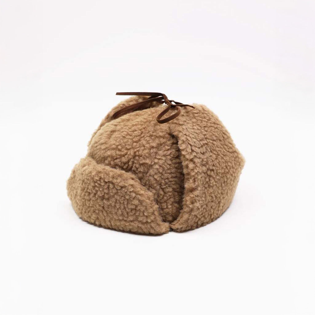 The Cableami Boa Aviator Hat in Camel is made from soft cotton Boa fleece with a textured finish, rounded shape, and small brown ribbon on top, shown against a plain white background.