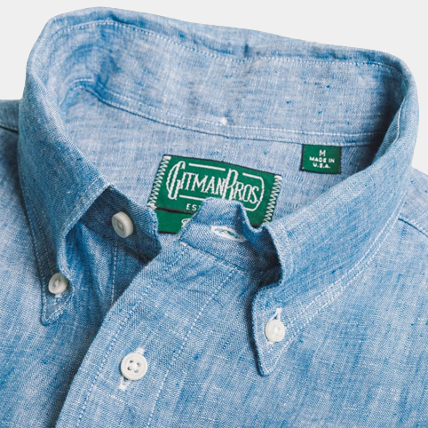 Close-up of a light blue chambray linen shirt with a visible "Gitman Vintage" label inside the collar.
