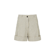 The Lee Shorts Check by Aiayu features cuffed hems, a black button, and a distinctive pattern of dark and light squares. Made from organic Chetna cotton, they combine style with sustainability and are GOTS certified.