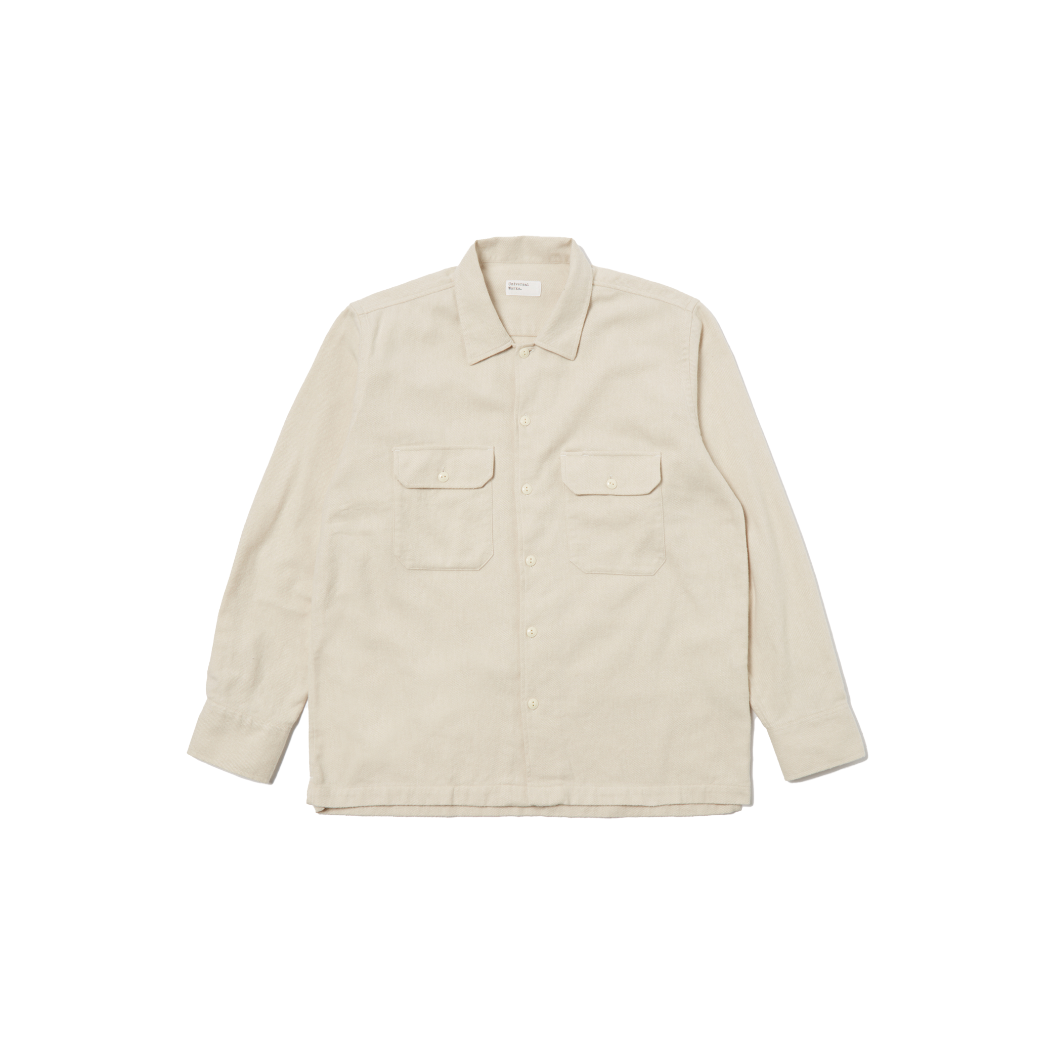A Universal Works LS Utility Shirt in beige, made from 100% cotton, showcases long sleeves and button flap chest pockets while laid flat against a black background.