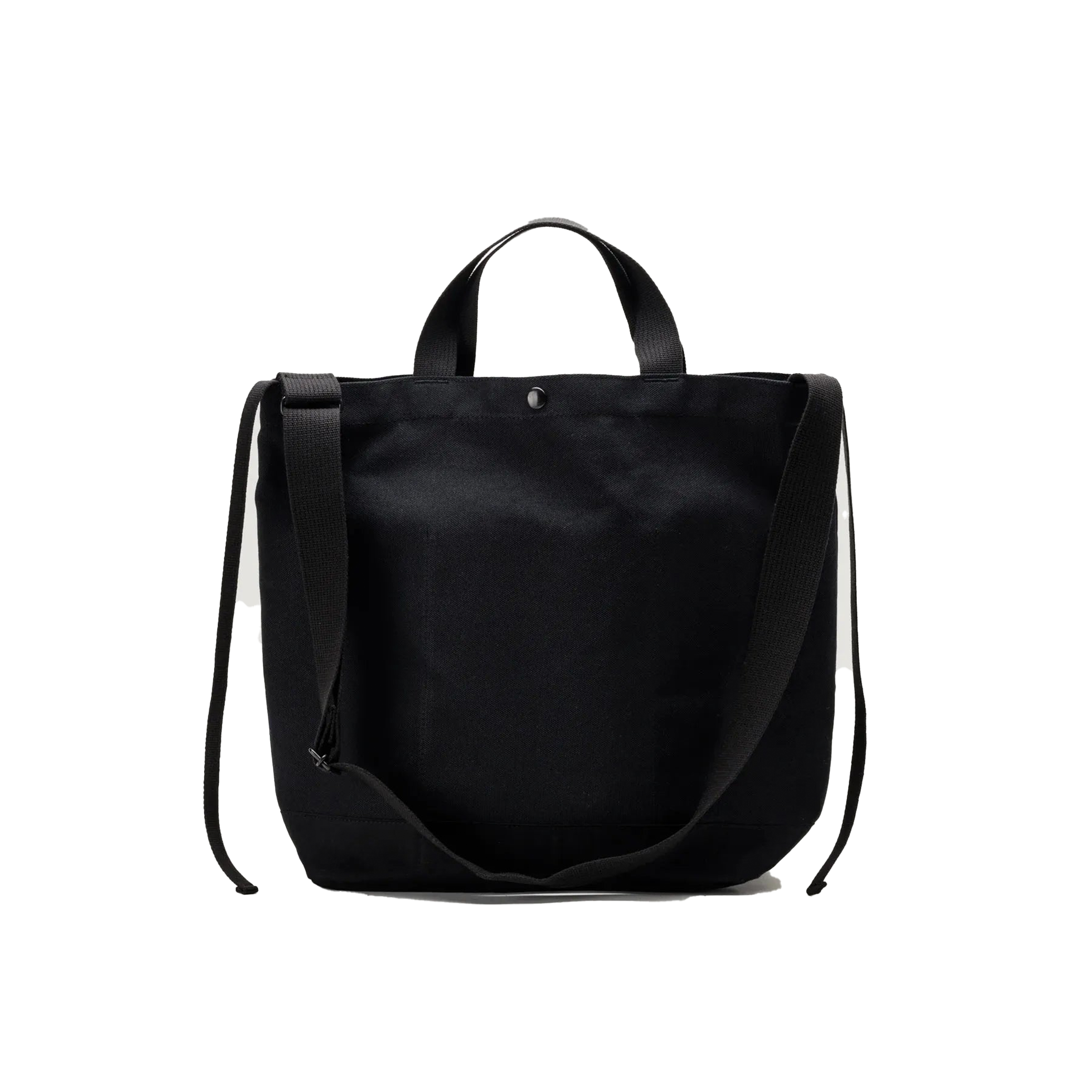 The Bags in Progress New York Tote Medium is a black cotton canvas bag made in Japan, featuring two short handles and a long adjustable shoulder strap, displayed against a white background.