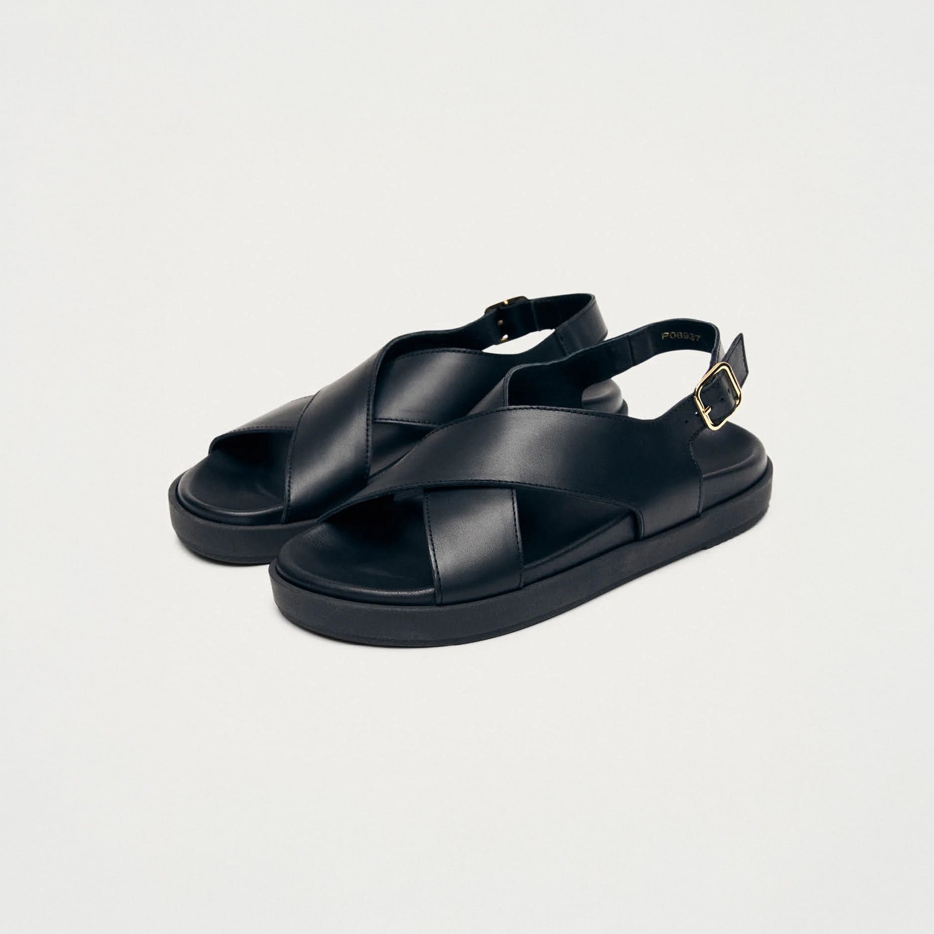 The Alohas Nico Sandal in black features comfortable leather with crisscross straps and an adjustable buckle, shown on a plain white background.