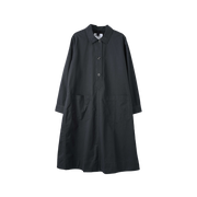 Margaret Howell's Swing Dress boasts a flowing silhouette with a collar, button closure, and two front patch pockets. Made from 100% cotton, it is showcased against a simple white background.