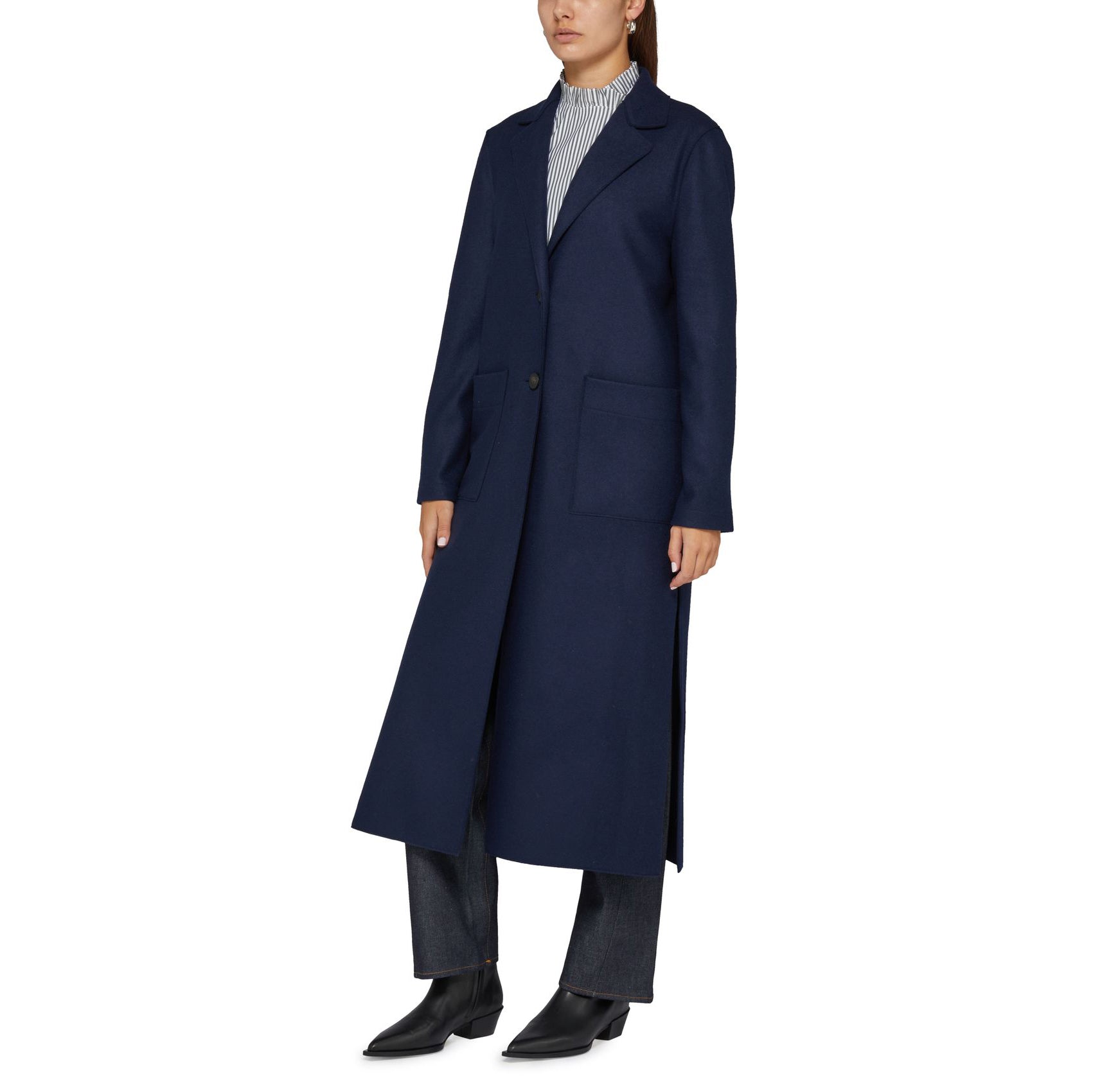 A person is wearing the Harris Wharf W Long Boxy Coat Cashmere in Navy, featuring large pockets, paired with dark jeans and black shoes.