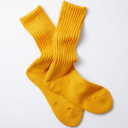 A pair of RoToTo Loose Pile Crew Socks in yellow is laid flat against a white background.
