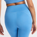 A person is seen from the back wearing a blue sports bra and Rohnisch's Flattering High Waist Bike Shorts, featuring stretchy, moisture-wicking fabric with visible seam details.