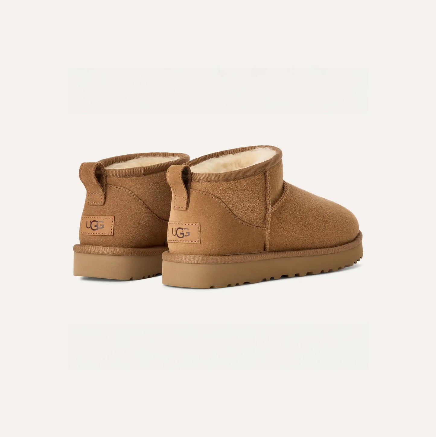 A rear and side view of Ugg's W Classic Ultra Mini brown suede boots, featuring shearling lining and an ultra-lightweight rubber sole.