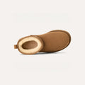 The W Classic Ultra Mini by Ugg is a brown slipper boot with UGG sheepskin, a shearling lining, an ultra-light sole, and a back loop. Its side profile is showcased against a plain background.