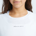 Close-up of a person wearing a breathable white Rohnisch Team Logo Singlet, with long brown hair partially visible.