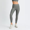 A person in Rohnisch Ribbed Regular High Waist Tights and sneakers stands against a white backdrop, exuding style and comfort.