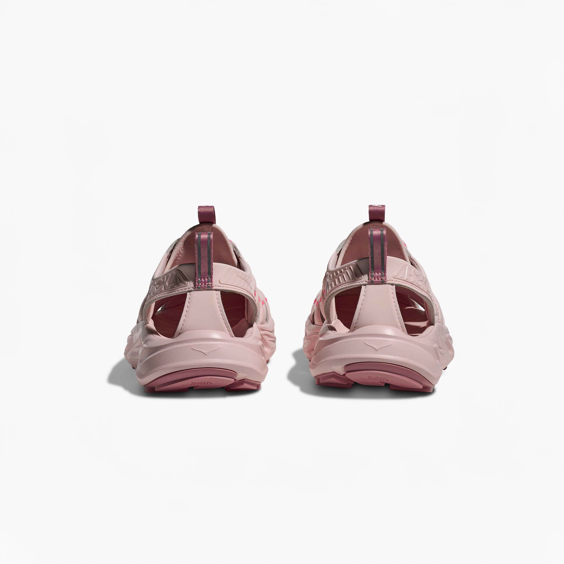 A pair of Hoka U Hopara sandals in Rose Tea/Neon Rose viewed from the back, showing open heels, pull tabs, and a Quick Lace system against a plain white background.