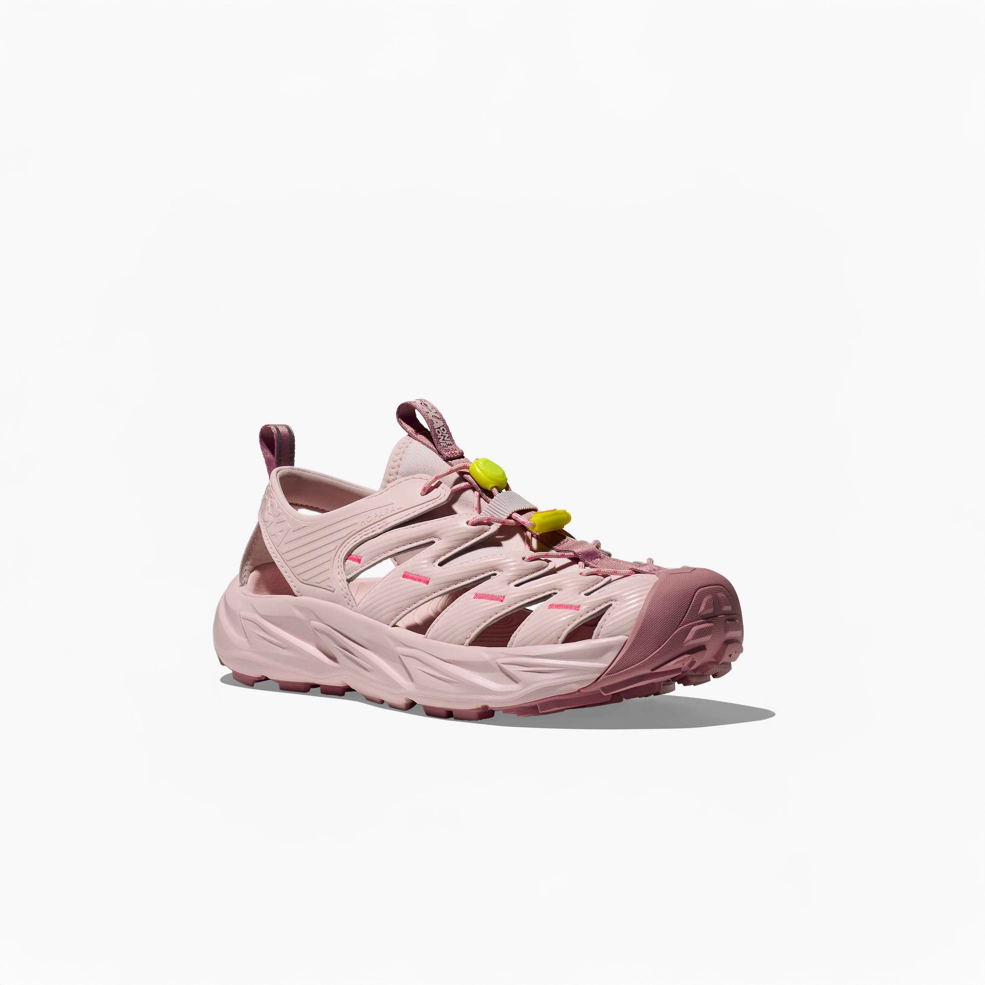 The Hoka U Hopara in Rose Tea/Neon Rose is a pink open-air sneaker inspired by hiking sandals, with a chunky sole, cut-out sides, Quick Lace system with yellow toggles, heel pull tab, and shown on a plain white background.