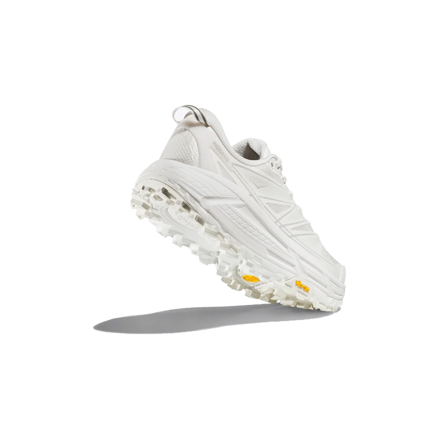 The Hoka U Mafate Speed 2 sneaker in White/Lunar Rock, shown from the back and side with a shadow on a plain white background, boasts a thick, textured sole ideal for trail adventures.