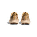 Rear view of a pair of Hoka M Clifton 9 running shoes in Wheat/Shifting Sand, featuring thick beige cushion soles for a responsive toe-off, set against a white background.